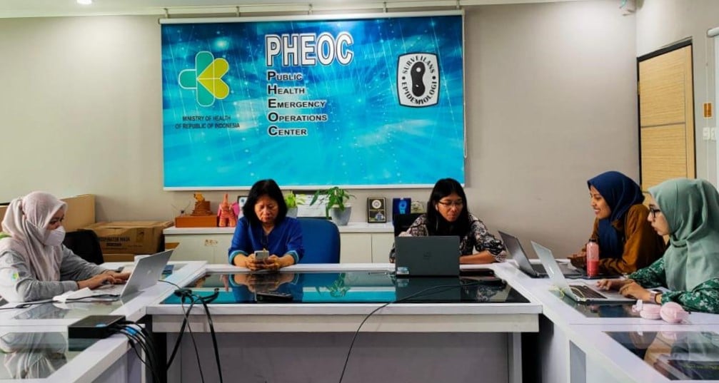 A meeting room with 5 officers joining online meeting