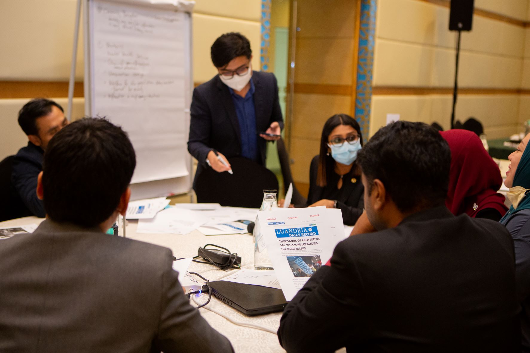 A group of public health professional sitting around a table looking at misinformation