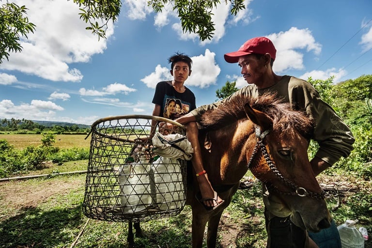 A father and his son, along with their horse, spend two hours walking to fetch water. They belong to 11 million Filipino families who are still deprived of clean water.